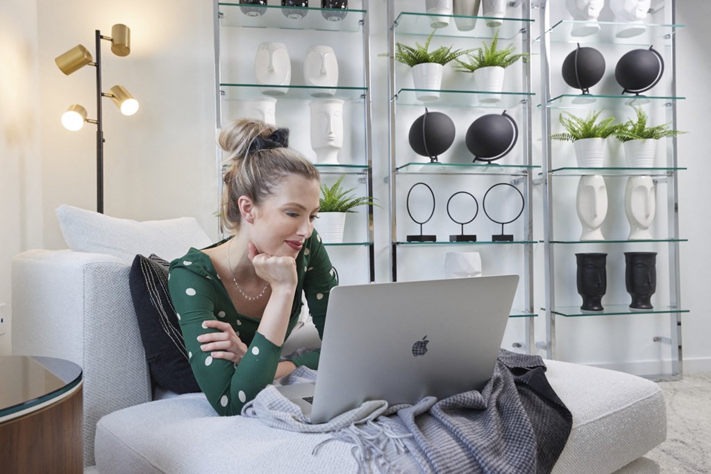 a woman sitting on a couch using a laptop computer