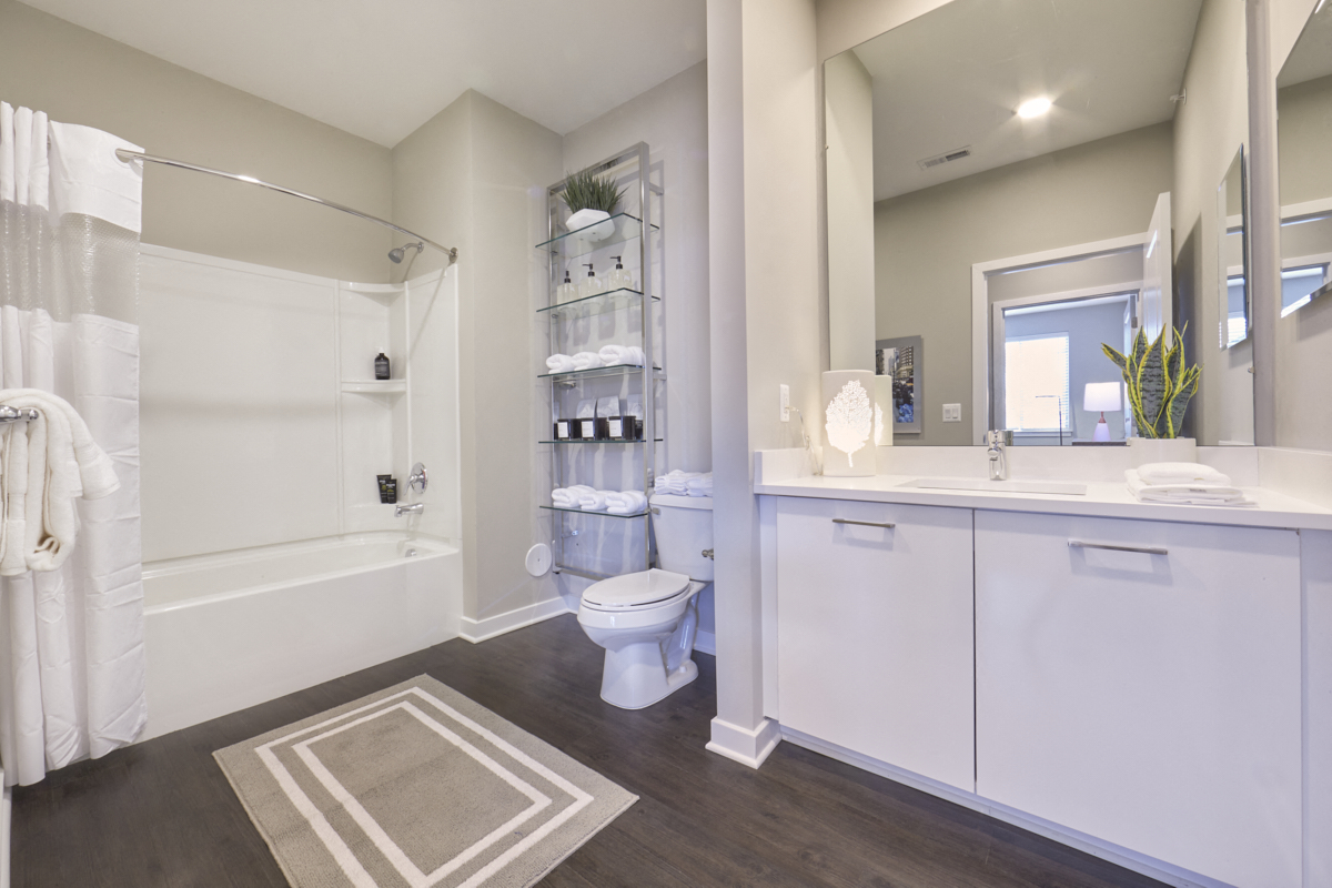 a bathroom with white cabinets and a white toilet and a shower