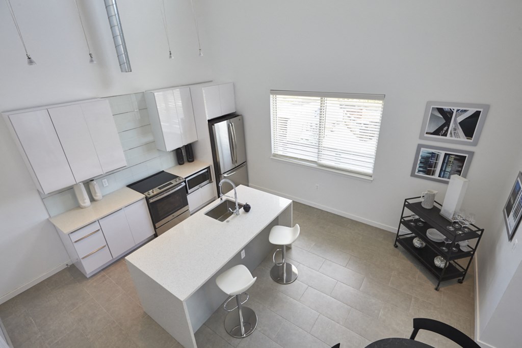an aerial view of a kitchen and living room with a table and chairs