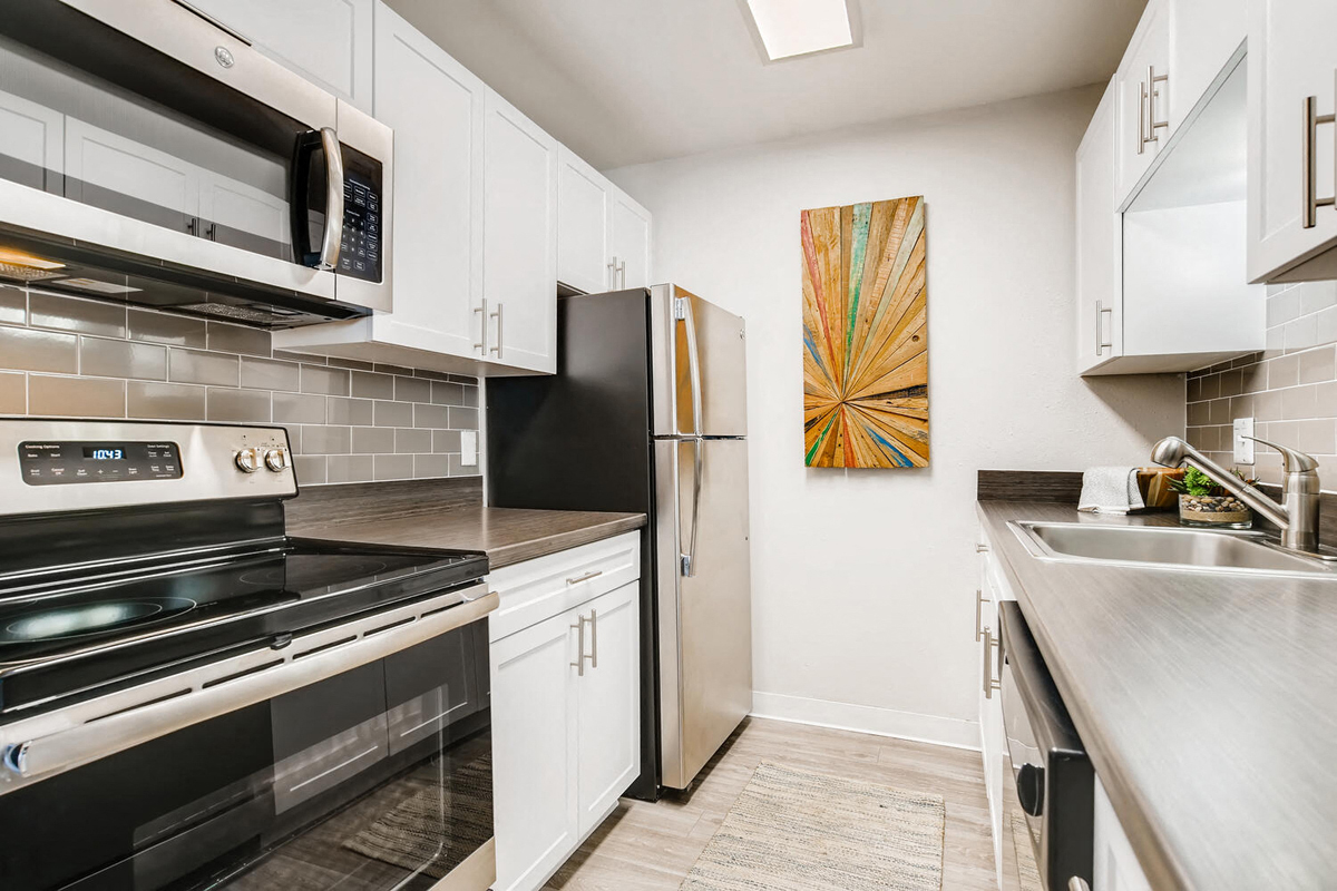 a kitchen with stainless steel appliances and white cabinets