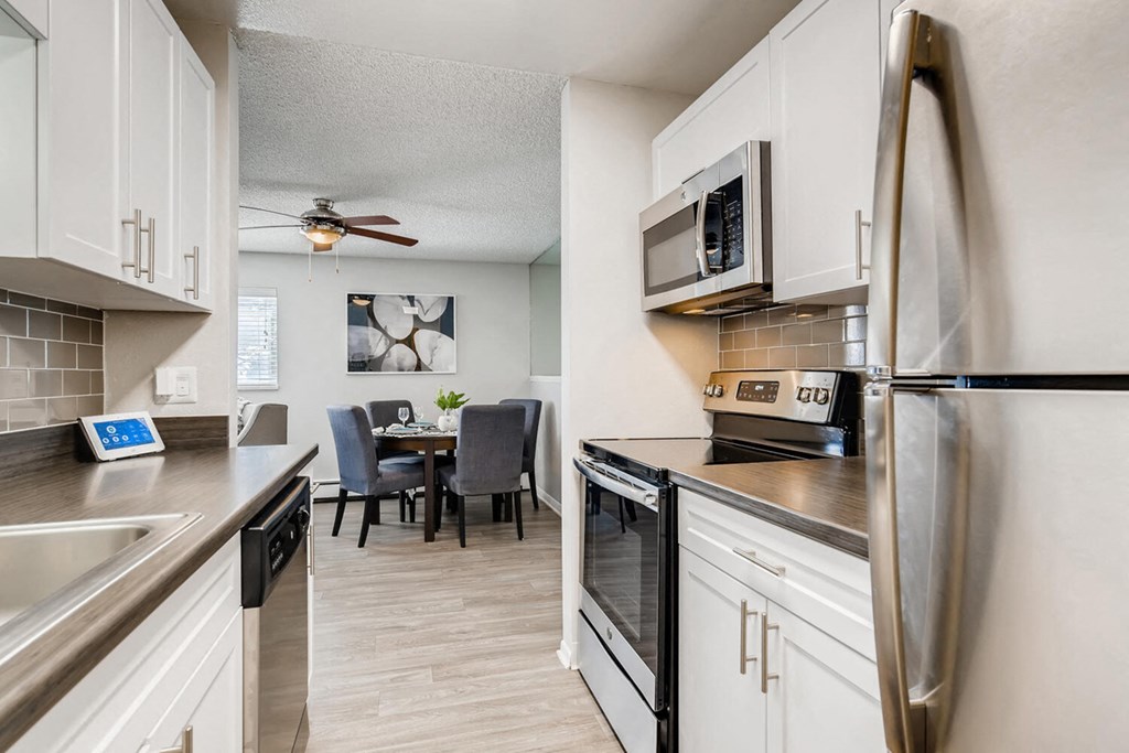 a kitchen and dining room with stainless steel appliances and a ceiling fan