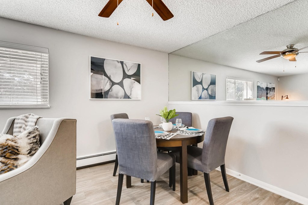 a dining room with a table and chairs and a ceiling fan