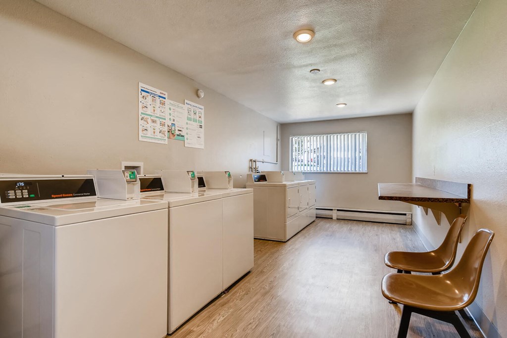 a kitchen with washers and dryers and a table and chairs