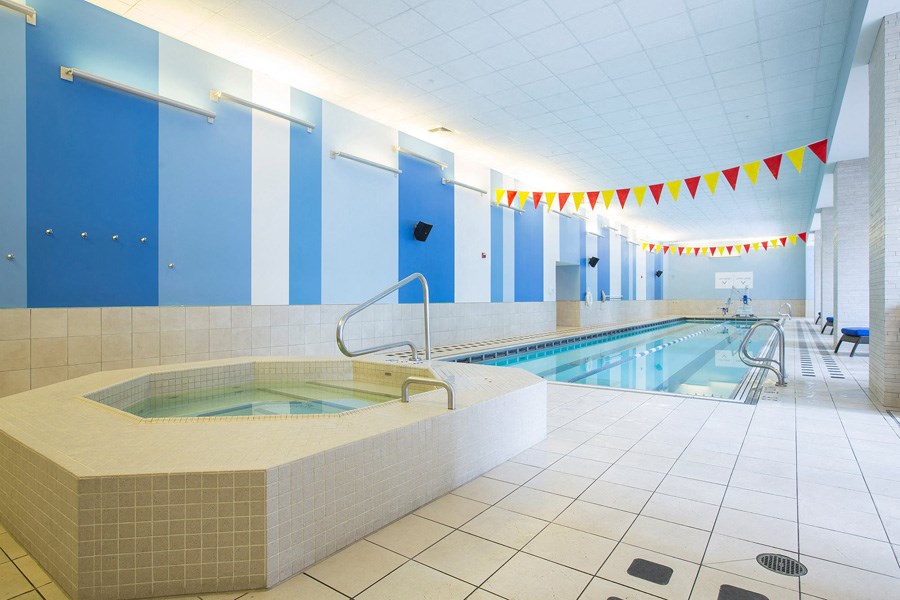 a swimming pool with a jacuzzi in a room with blue walls
