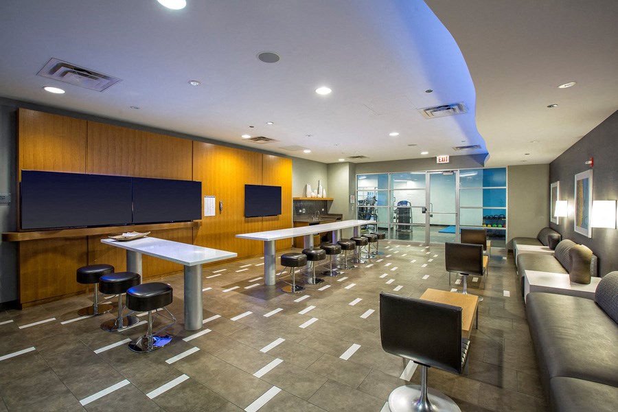 a lounge area with tables and chairs and a television