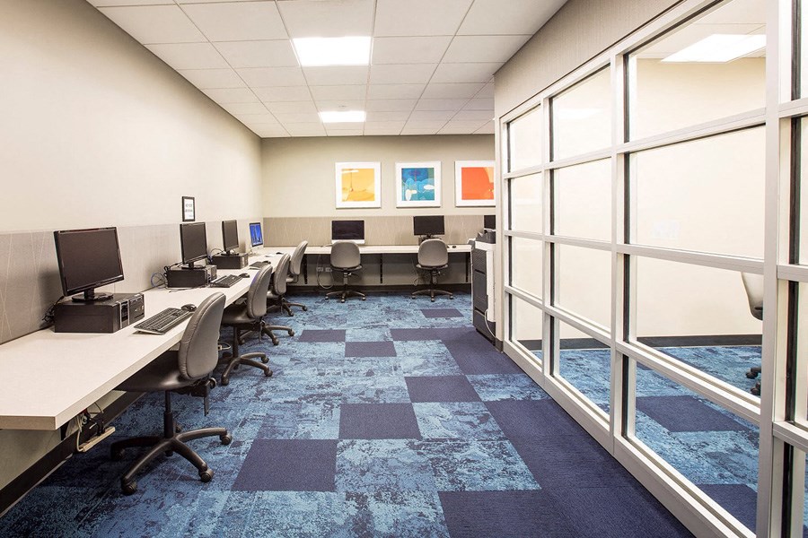 a conference room with desks and chairs and windows