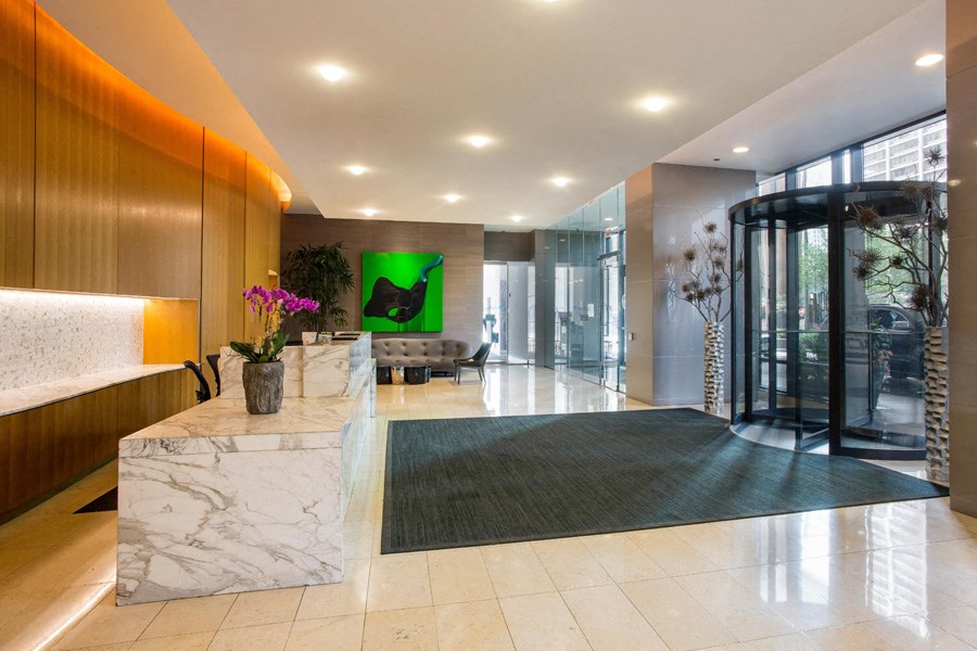 a lobby with a marble reception desk and a glass door