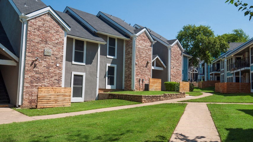a row of houses on the side of a sidewalk