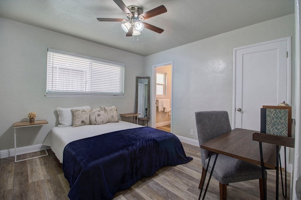 a bedroom with a bed and a ceiling fan