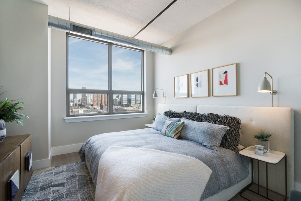 a bedroom with a bed and a large window