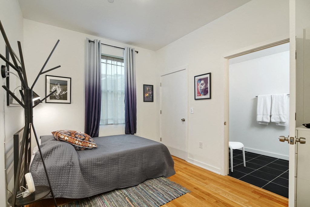 a bedroom with a bed and a door to a bathroom