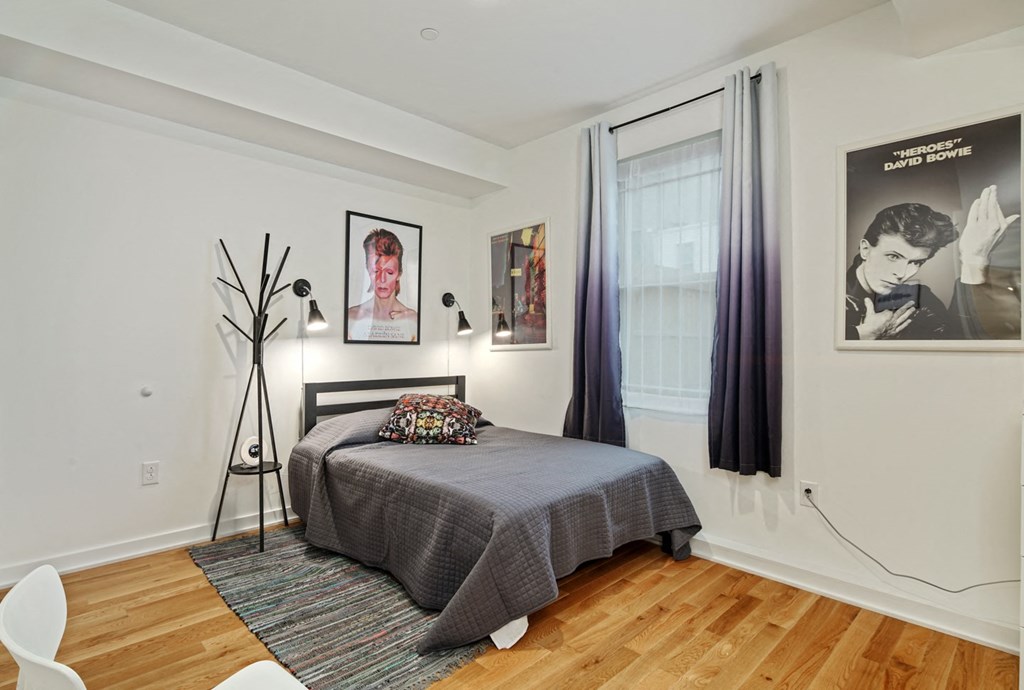 a bedroom with a bed and posters on the wall