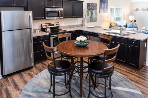 a kitchen with a round table and black cabinets