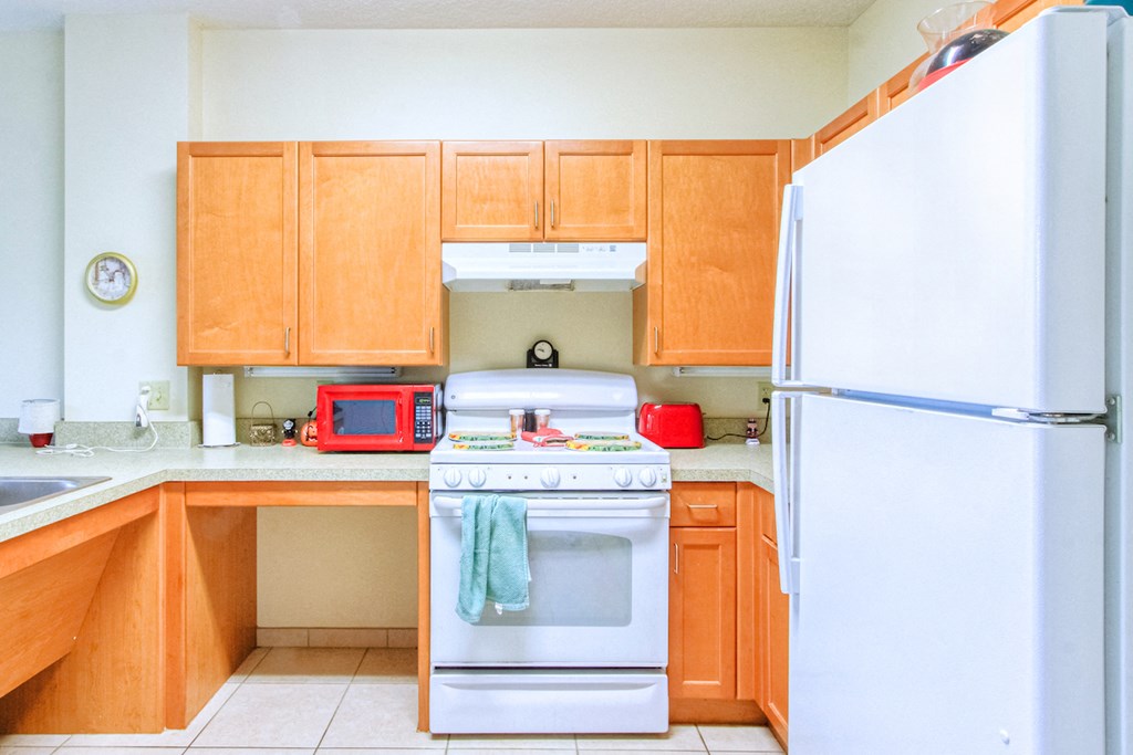 a kitchen with wooden cabinets and a white stove and refrigerator