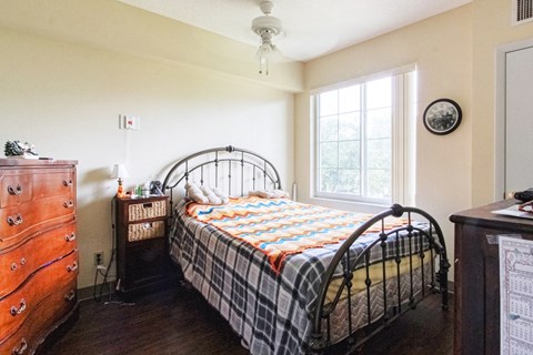 a bedroom with a bed and a dresser and a window