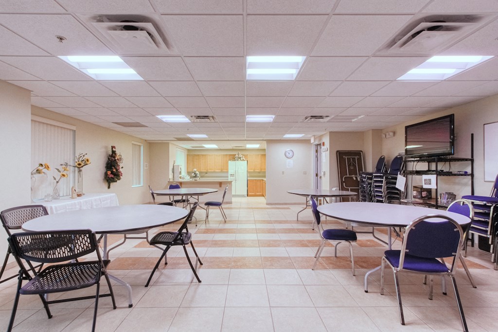 a dining room with tables and chairs and a kitchen
