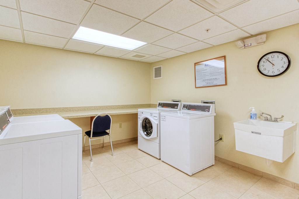 a laundry room with two washing machines and a clock