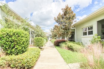 apartments with lush, mature landscaping and neat sidewalks
