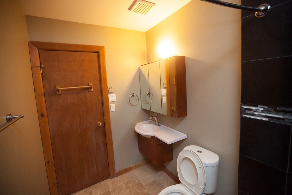 a bathroom with a toilet and a sink and a mirror
