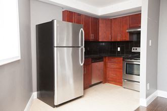 a kitchen with a stainless steel refrigerator and wooden cabinets