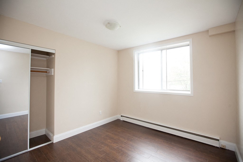 an empty room with a closet and a window