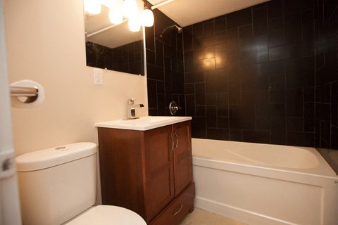 a bathroom with a toilet and a tub and a sink