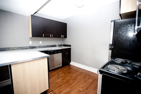 a small kitchen with black appliances and wood flooring