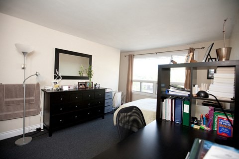 a bedroom with a bed and a black dresser