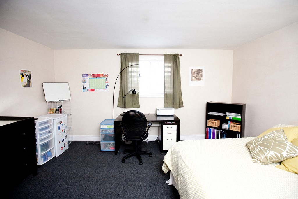 a small bedroom with a bed and a desk