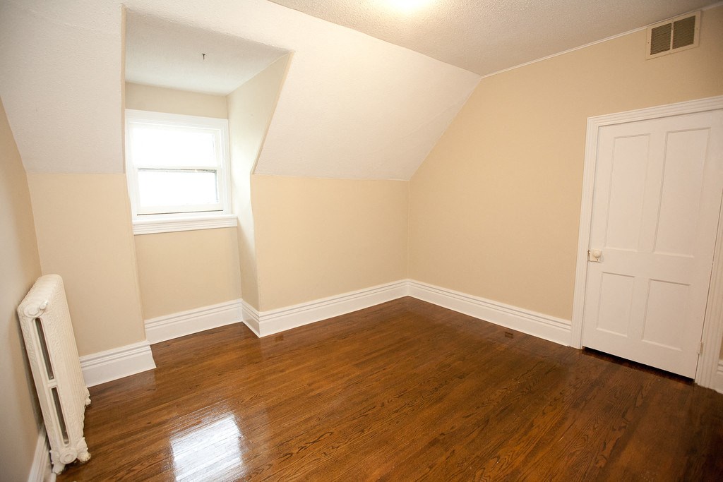 an empty room with wooden floors and a white door