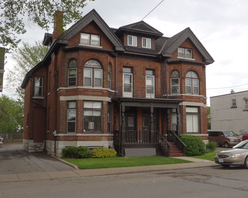 a red brick house on the corner of a street