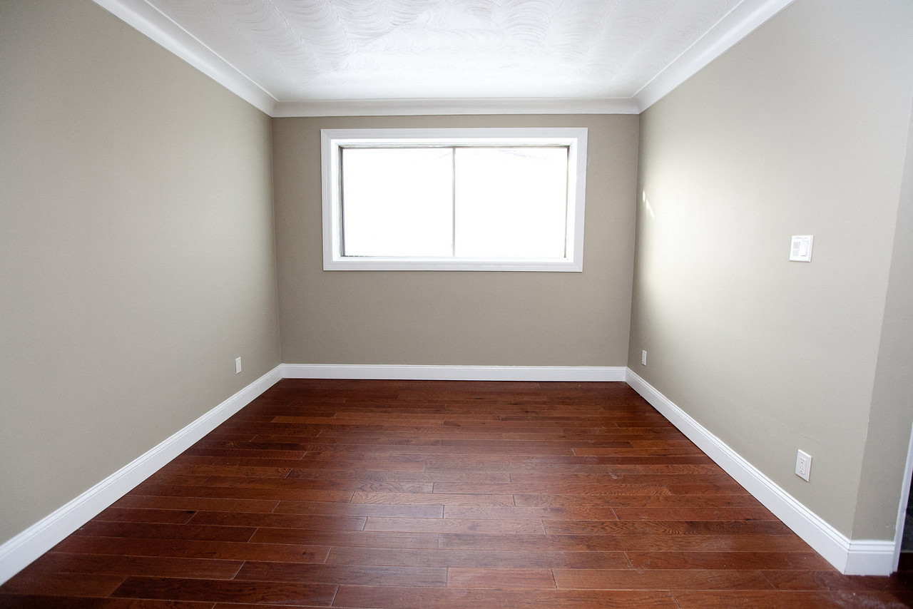 a empty room with wooden floors and a window