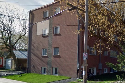 a brick building with windows on the side of a street