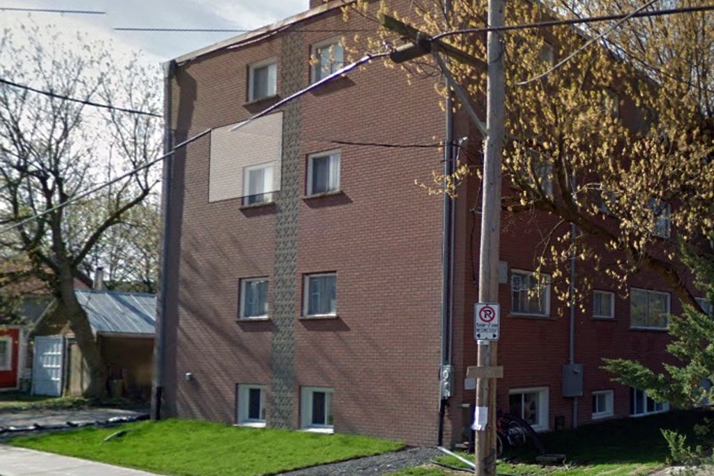 a brick building with windows on the side of a street
