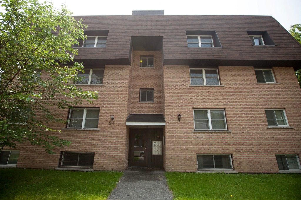 the front of a brick building with a sidewalk in front