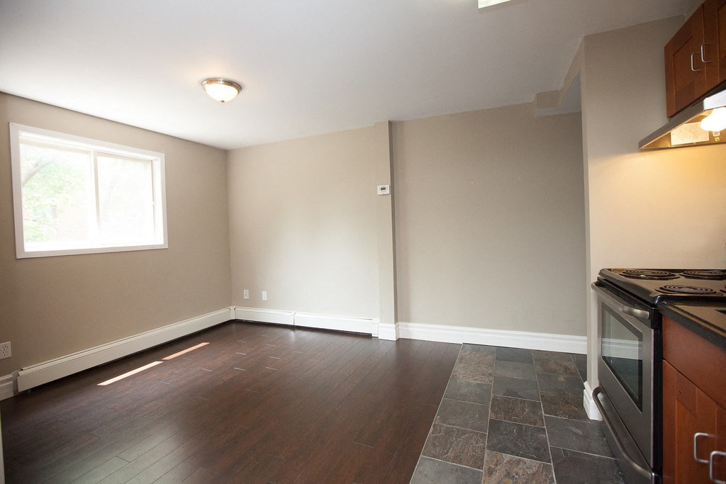 an empty kitchen with a stove and a window