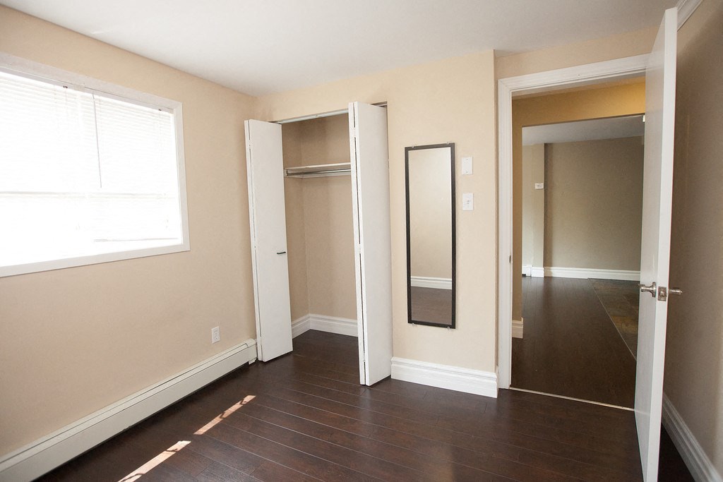 a bedroom with a mirror and a hallway to a closet