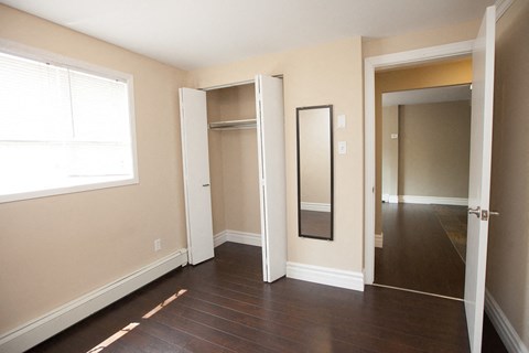 a bedroom with a mirror and a hallway to a closet