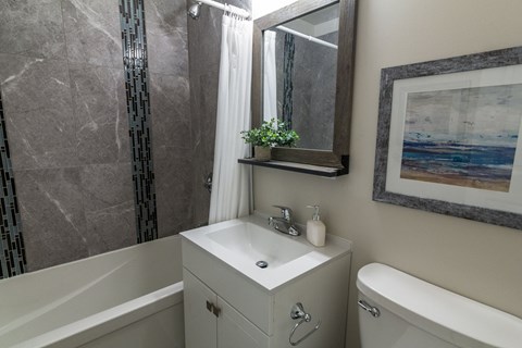 A bathroom with a white sink and a white bathtub.