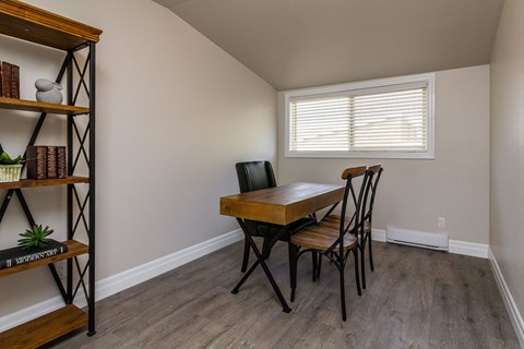 A room with a wooden table and chairs.
