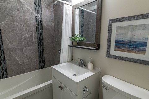 A bathroom with a white sink and a white bathtub.