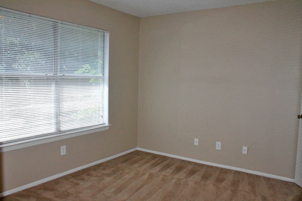 a room with a large window and a wooden floor