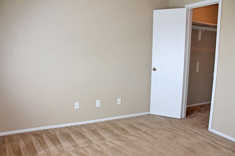 an empty room with a closet and a door to a closet
