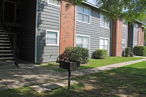 a sidewalk in front of a building with a mailbox