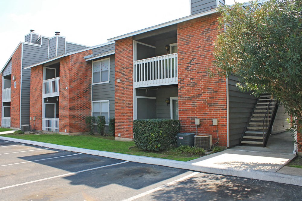 an exterior view of an apartment building with stairs and a sidewalk