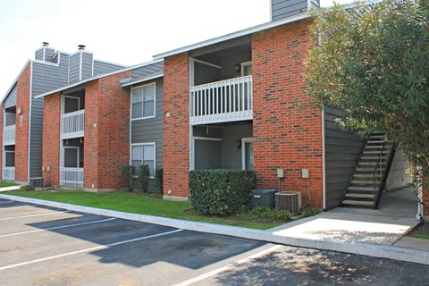an exterior view of an apartment building with stairs and a sidewalk