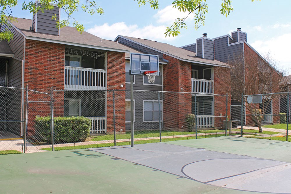 a basketball court in front of an apartment building