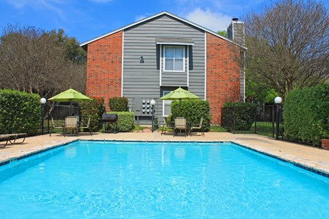 a swimming pool in front of a house with a pool