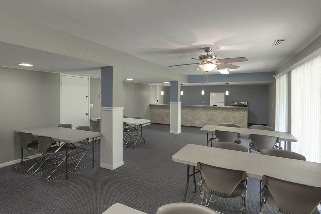 a conference room with tables and chairs and a ceiling fan