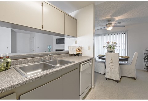 a kitchen and living room with a ceiling fan and a sink